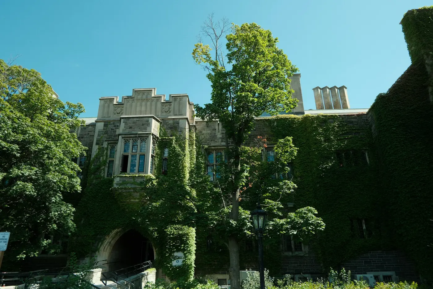 An ivy-covered stone building with an arched entrance