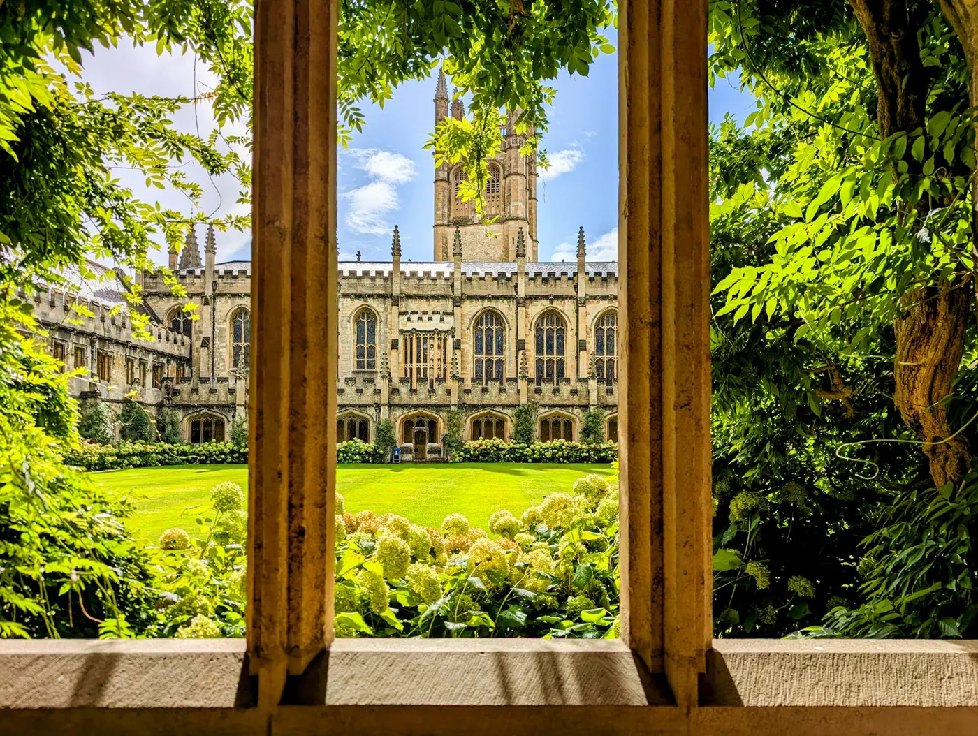 A college quadrangle seen through a stone window